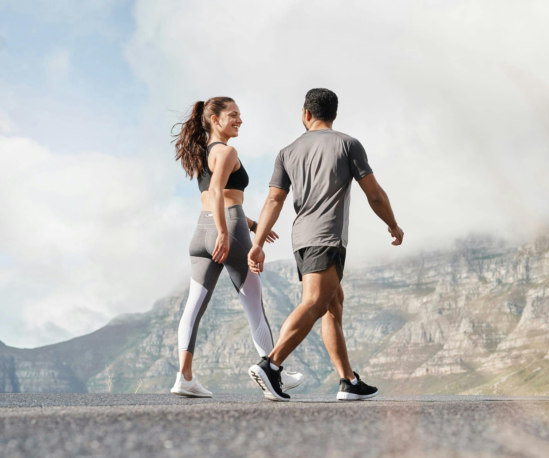 there are two people walking on the road holding hands