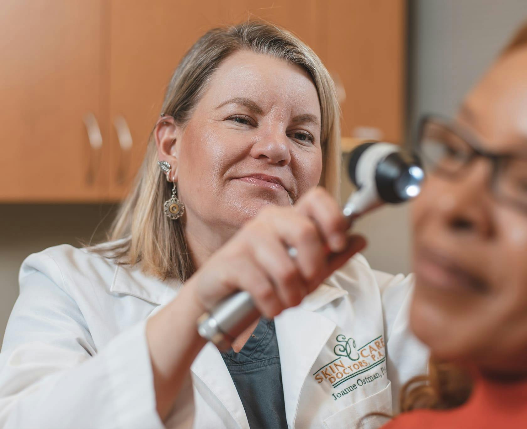 woman getting her ear examined by a doctor