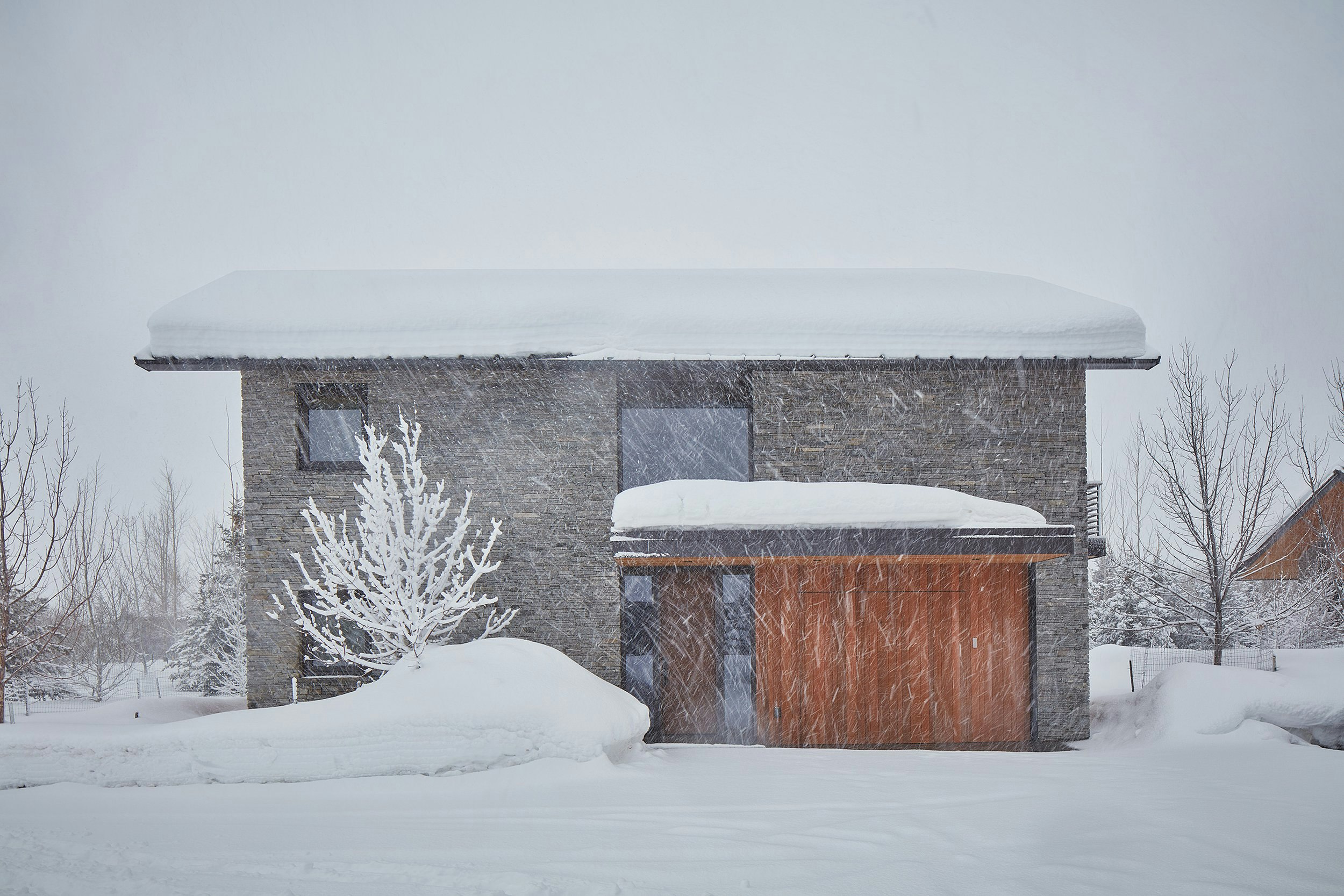Exterior of a stone guest house during a snow storm