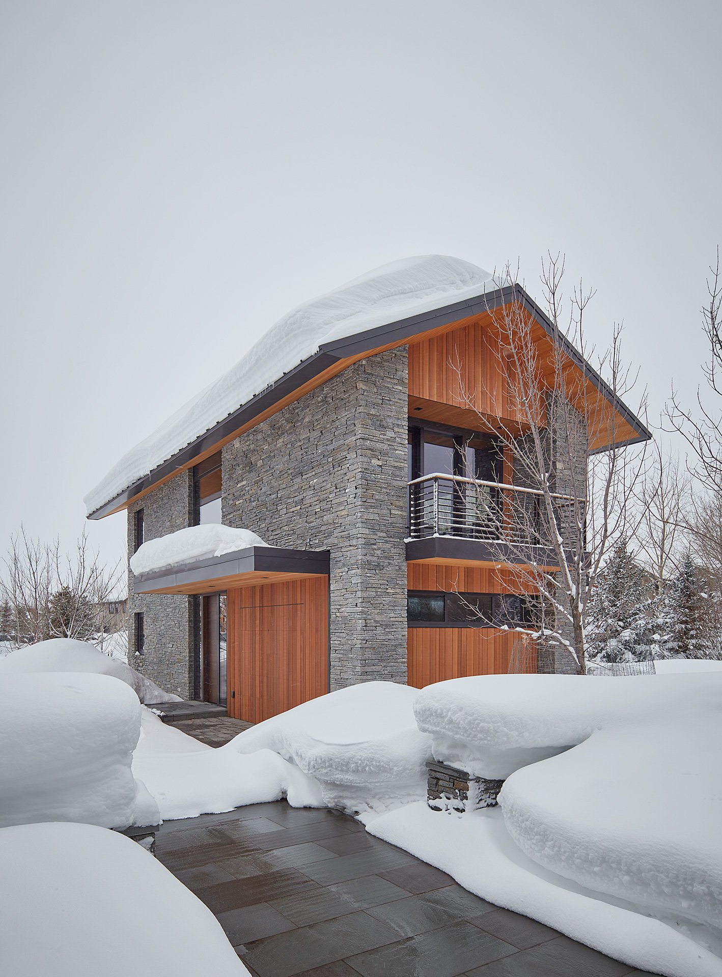 Guest house made of stone and wood covered in snow