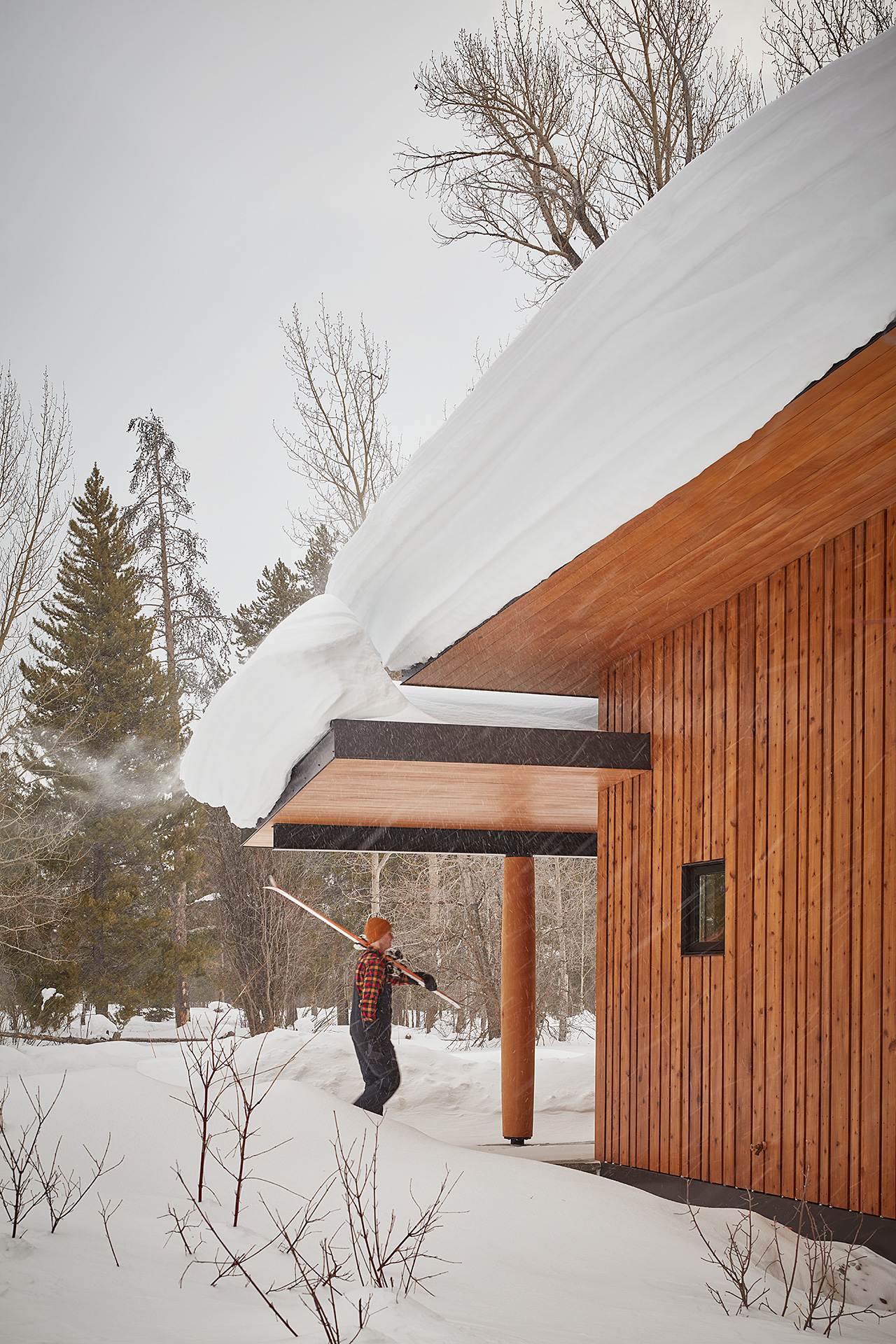 guest house in the winter with man carrying ski's outside