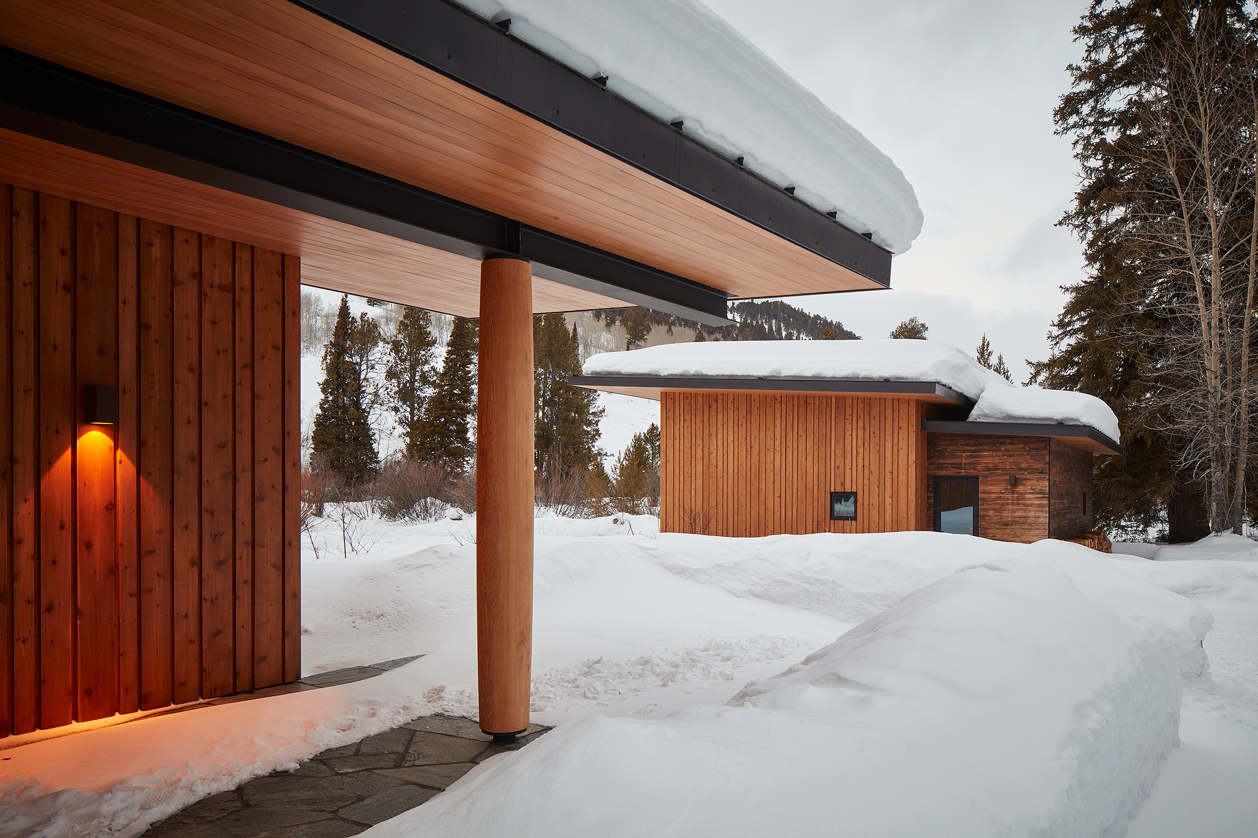 exterior view of a guest house and garage side profile in the winter snow