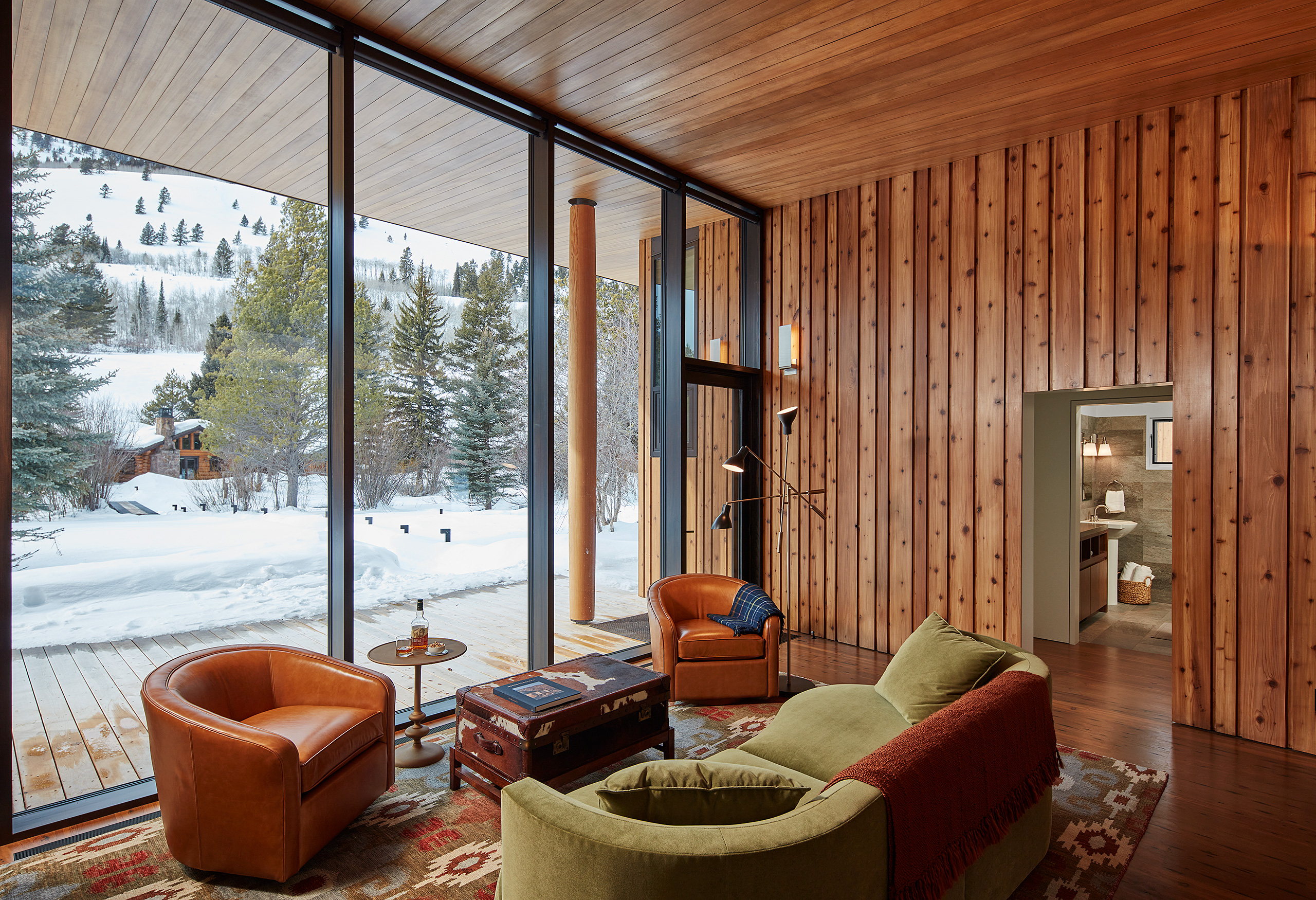 Living room of a guest house showcasing floor to ceiling windows