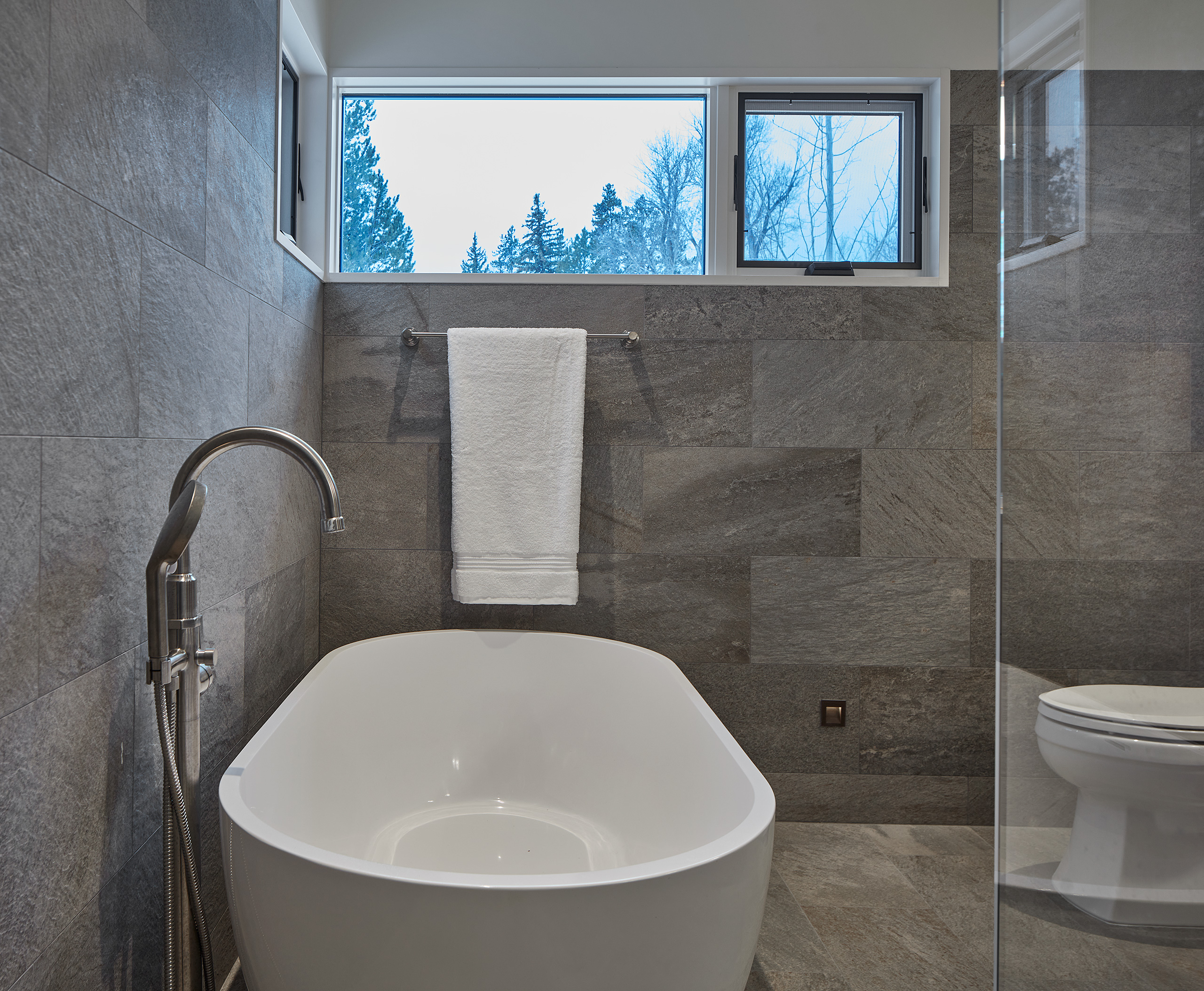 bathroom with gray slate walls and soaking tub