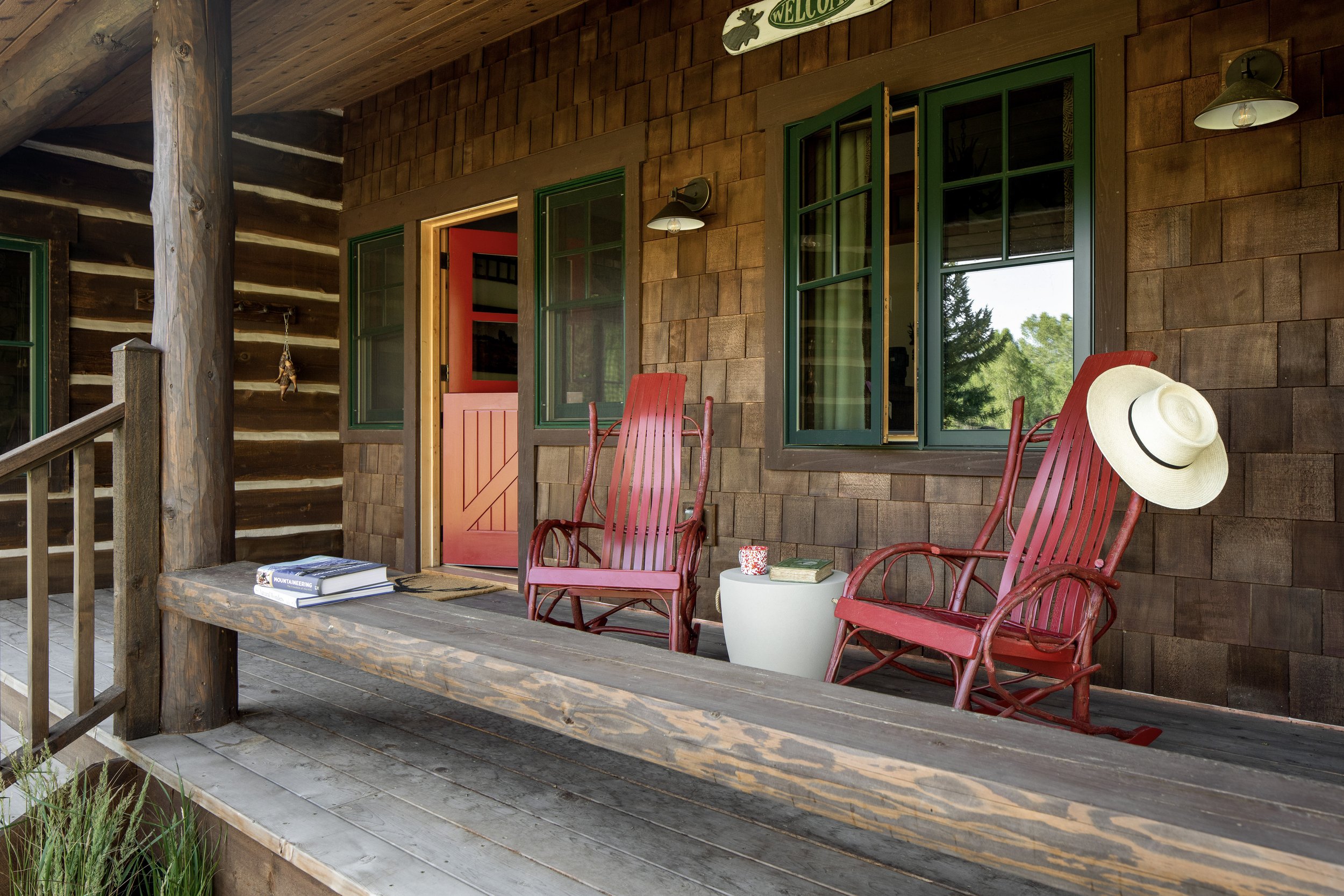 Red rocking chairs on the front porch of a cabin