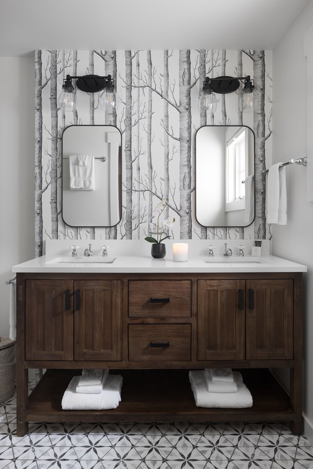 Bathroom double sink with two mirrors, a vanity, and woods wallpaper