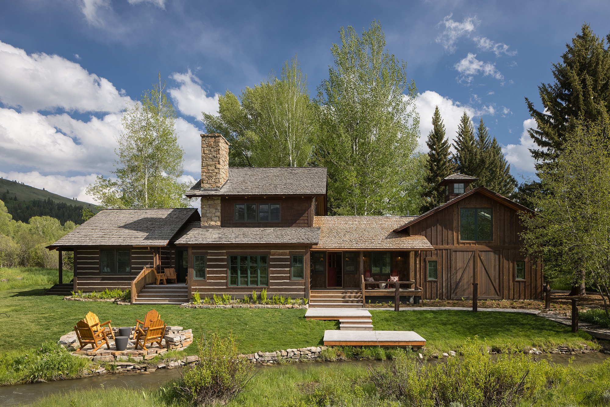 Backyard of a cabin with fire pit and creek