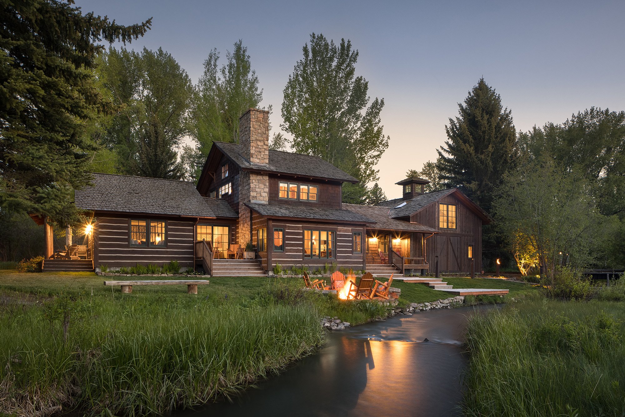 Cabin at dusk with a creek in the front yard