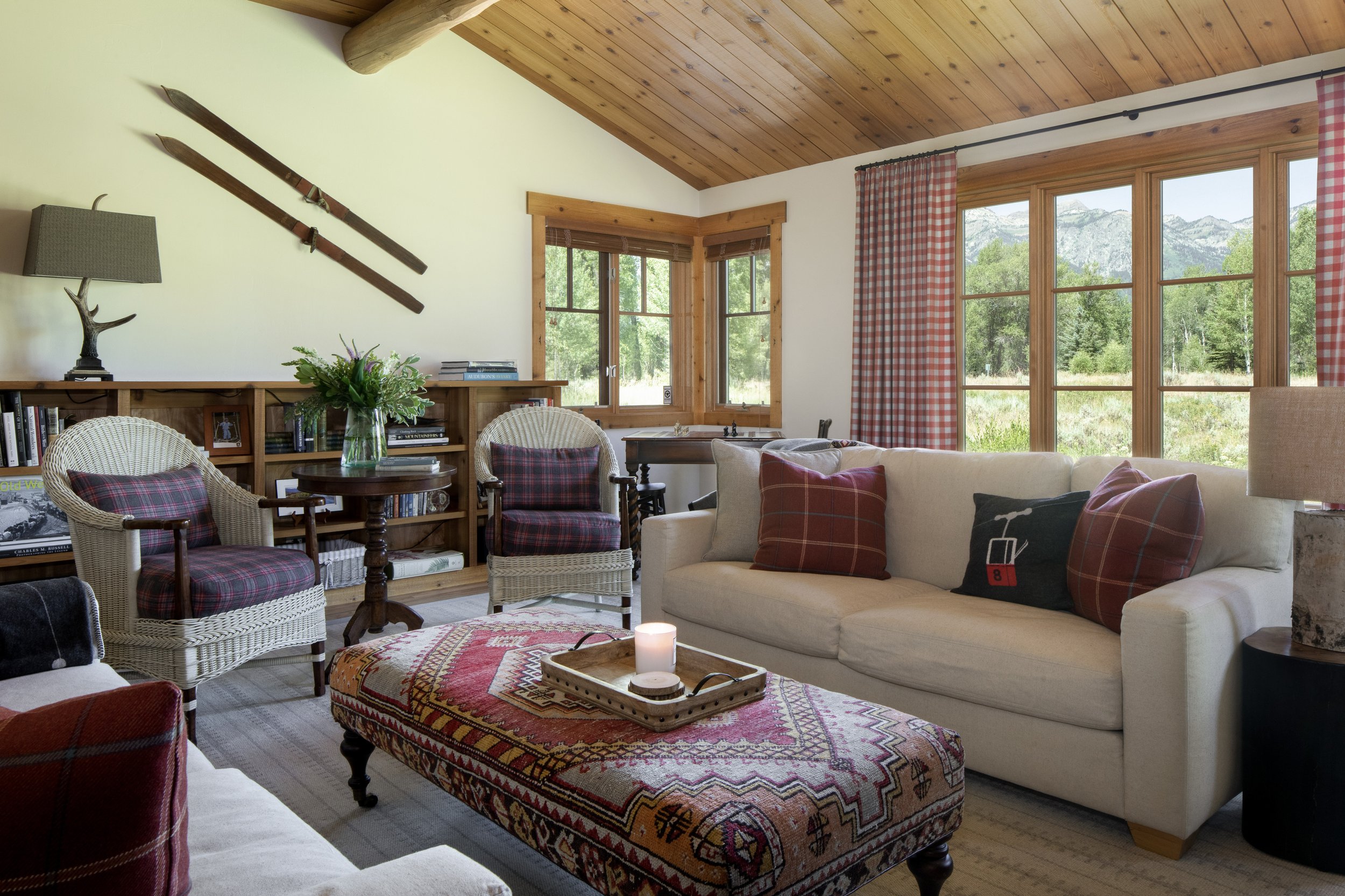 Cabin den seating area with ski's on wall and cabin decor