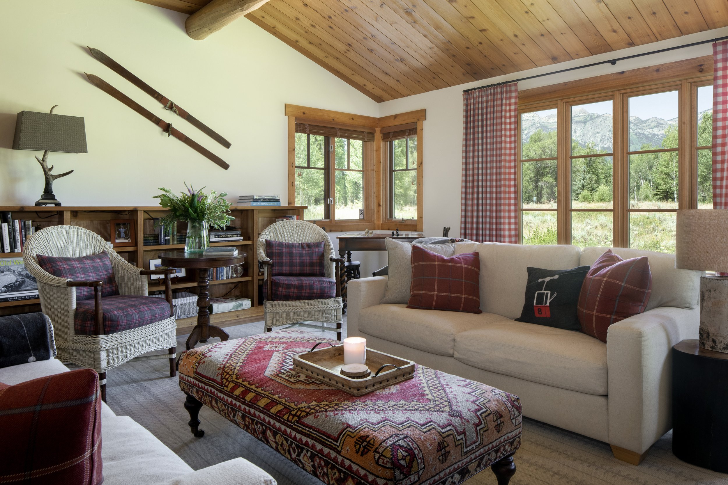 Cabin den seating area with ski's on wall and cabin decor