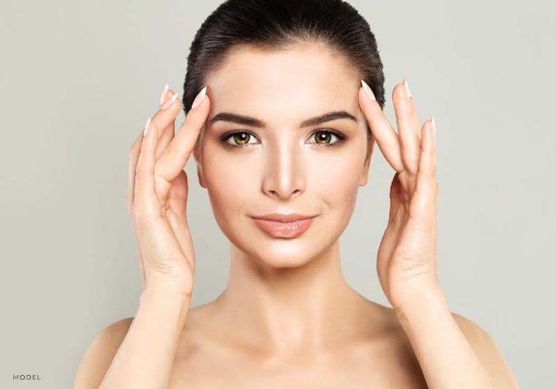 A woman touching sides of her face