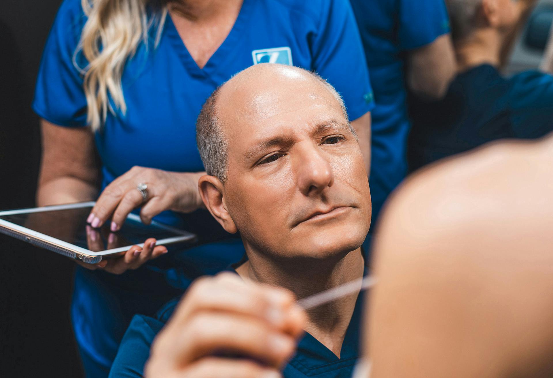 Dr. Zenn with a nurse behind him on an ipad