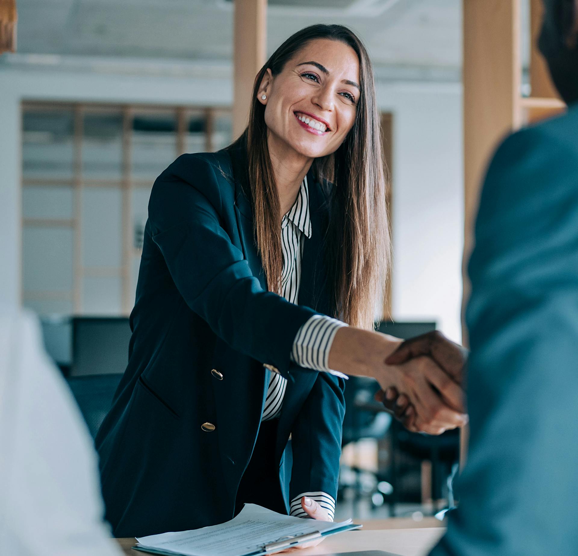 Woman in a black jacket shaking hands with someone