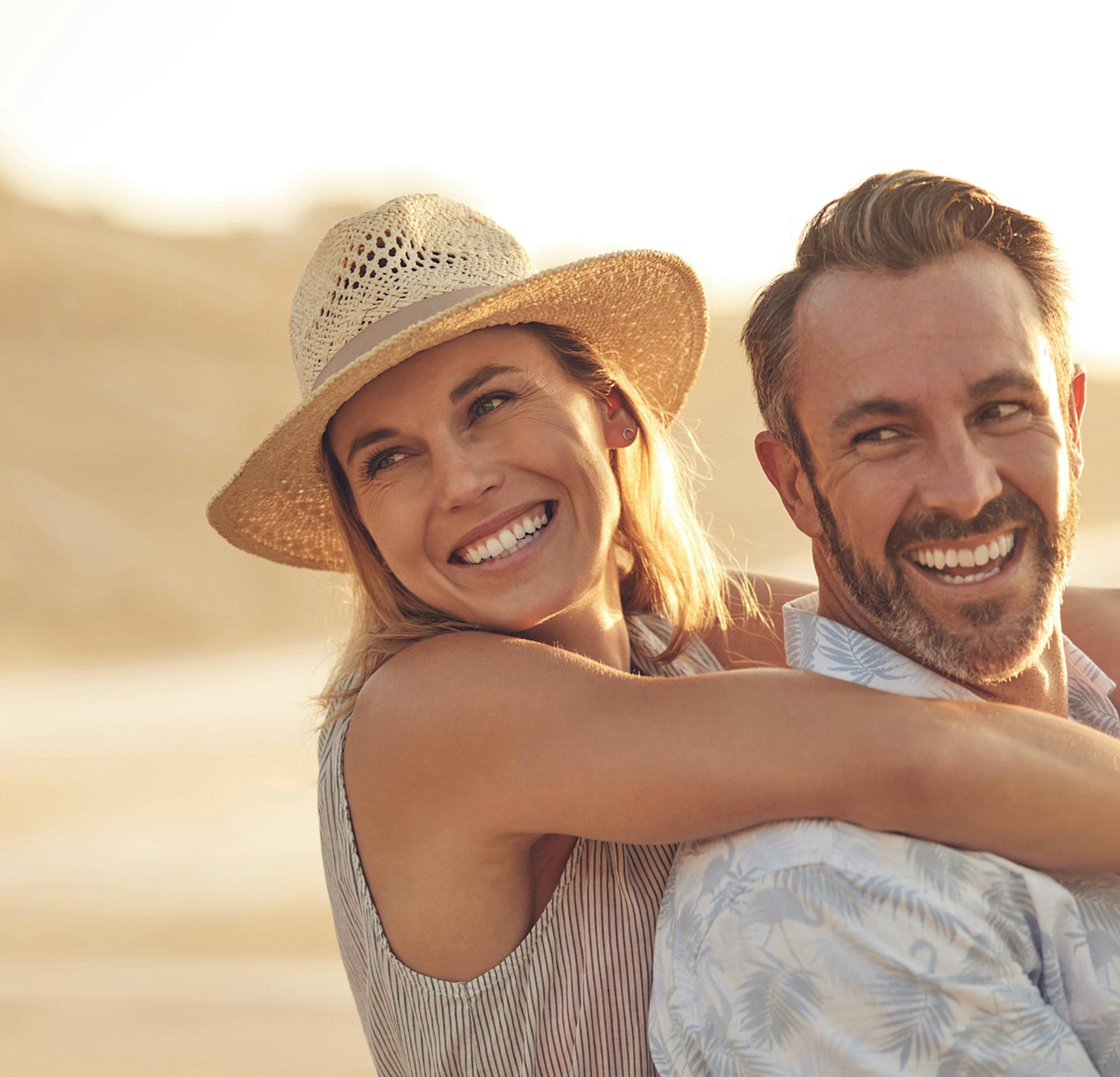 Woman in a large hat hugging a man from behind