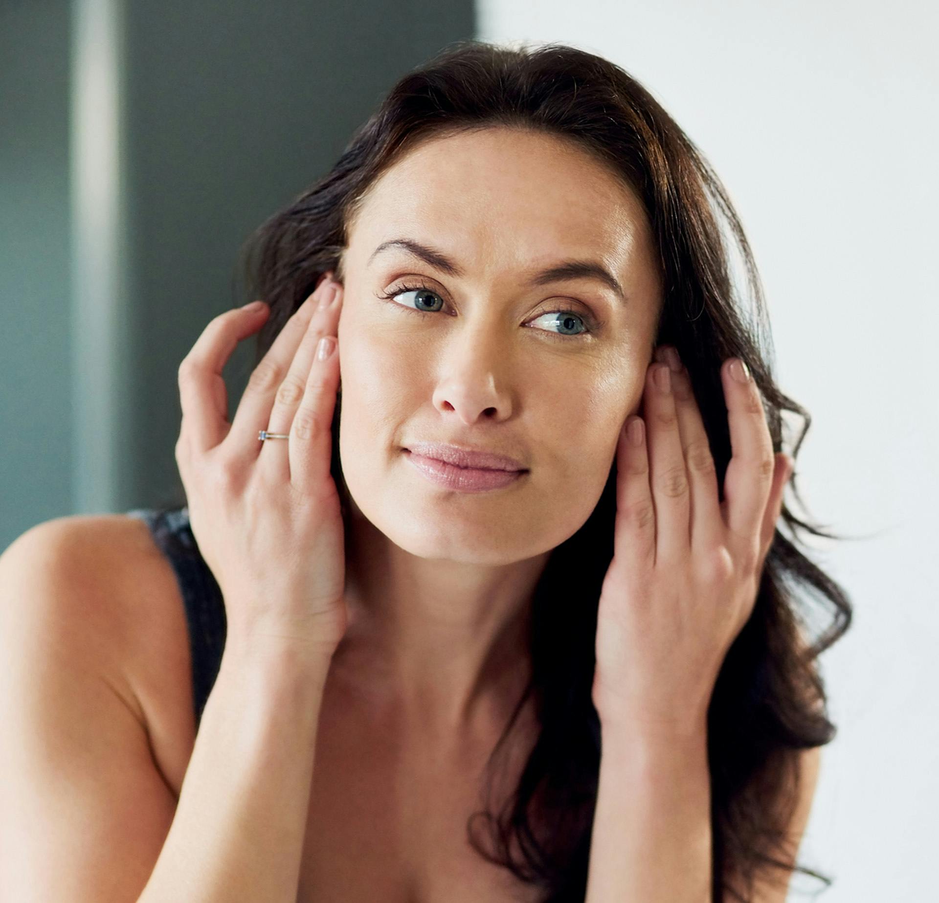 Woman pulling her hair back behind her ears