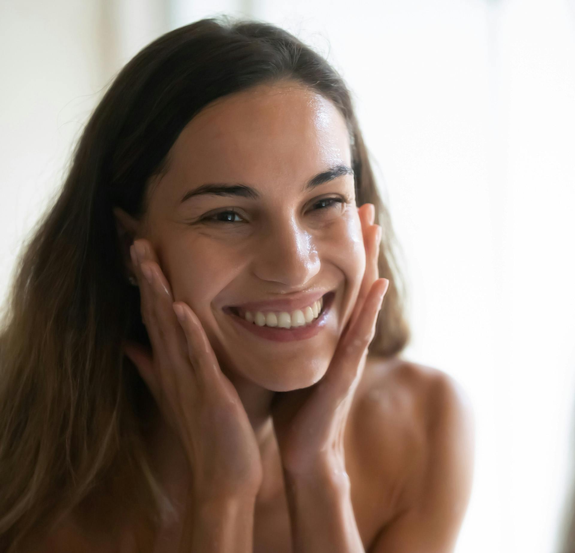 Woman smiling with her hands on her cheeks