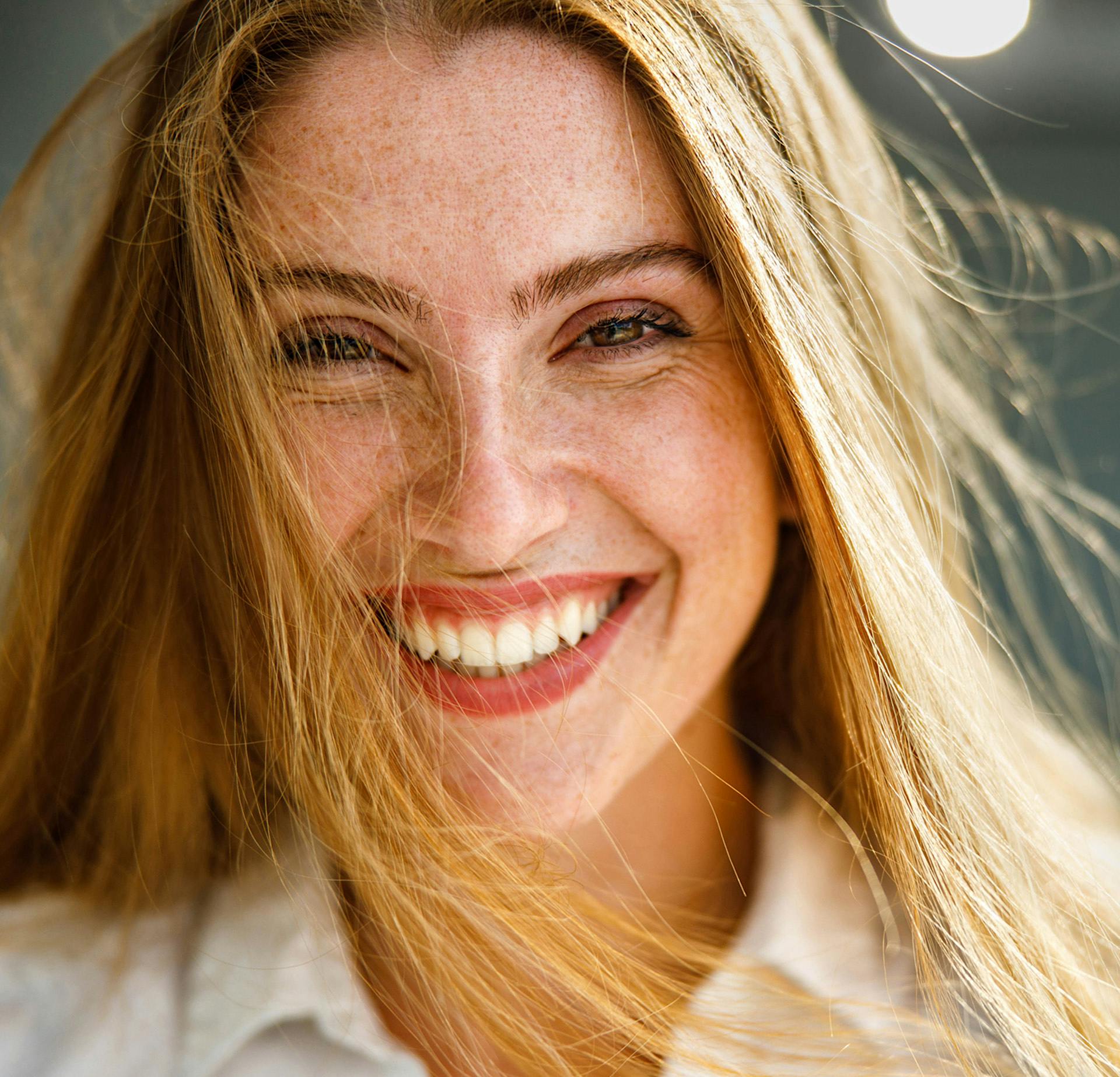Woman with her hair in her face smiling