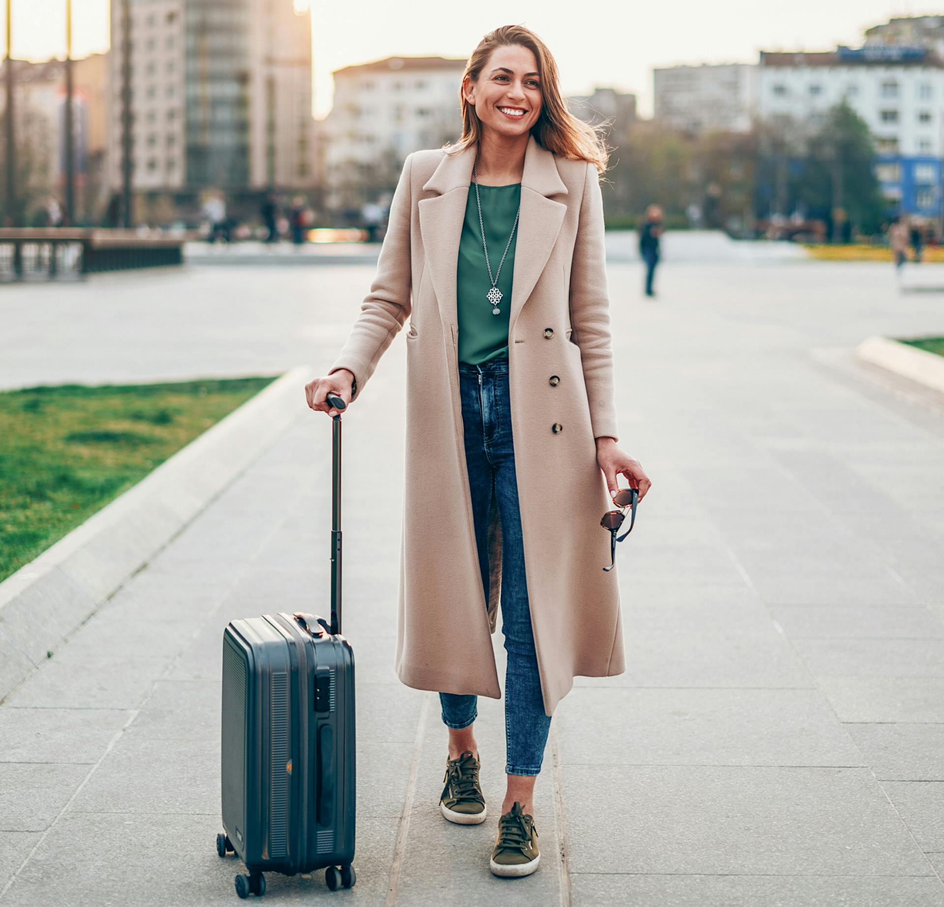 Woman with luggage on the sidewalk