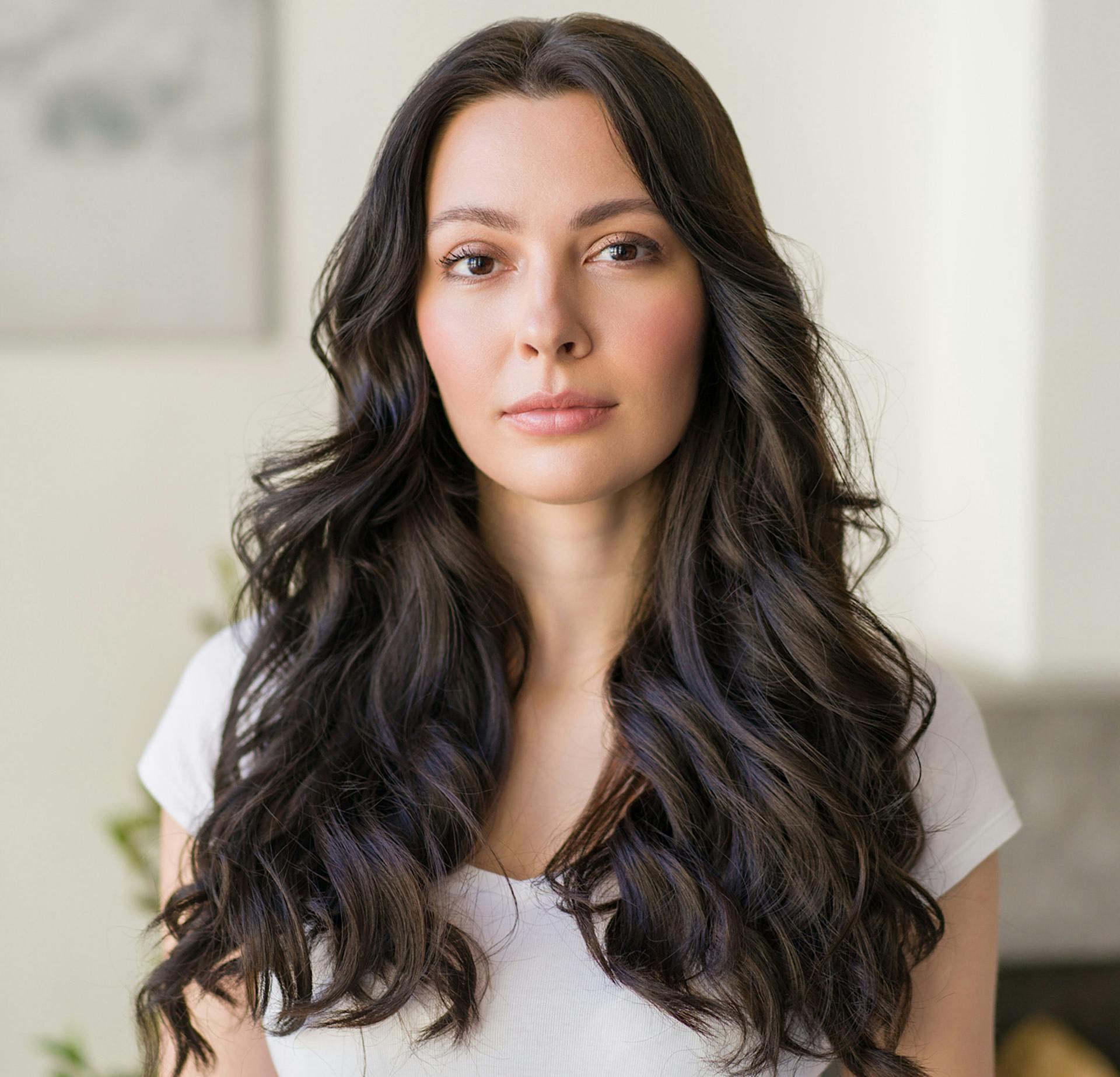Woman with curly black hair and a white shirt