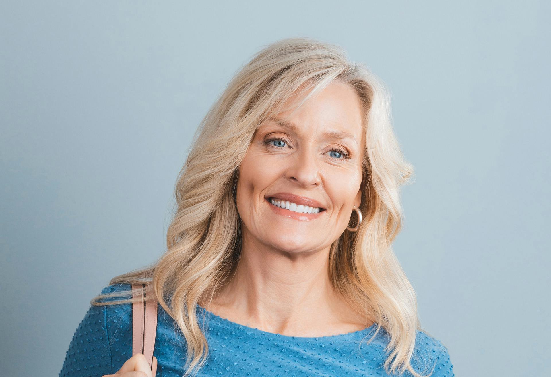 Blonde woman in a blue shirt smiling