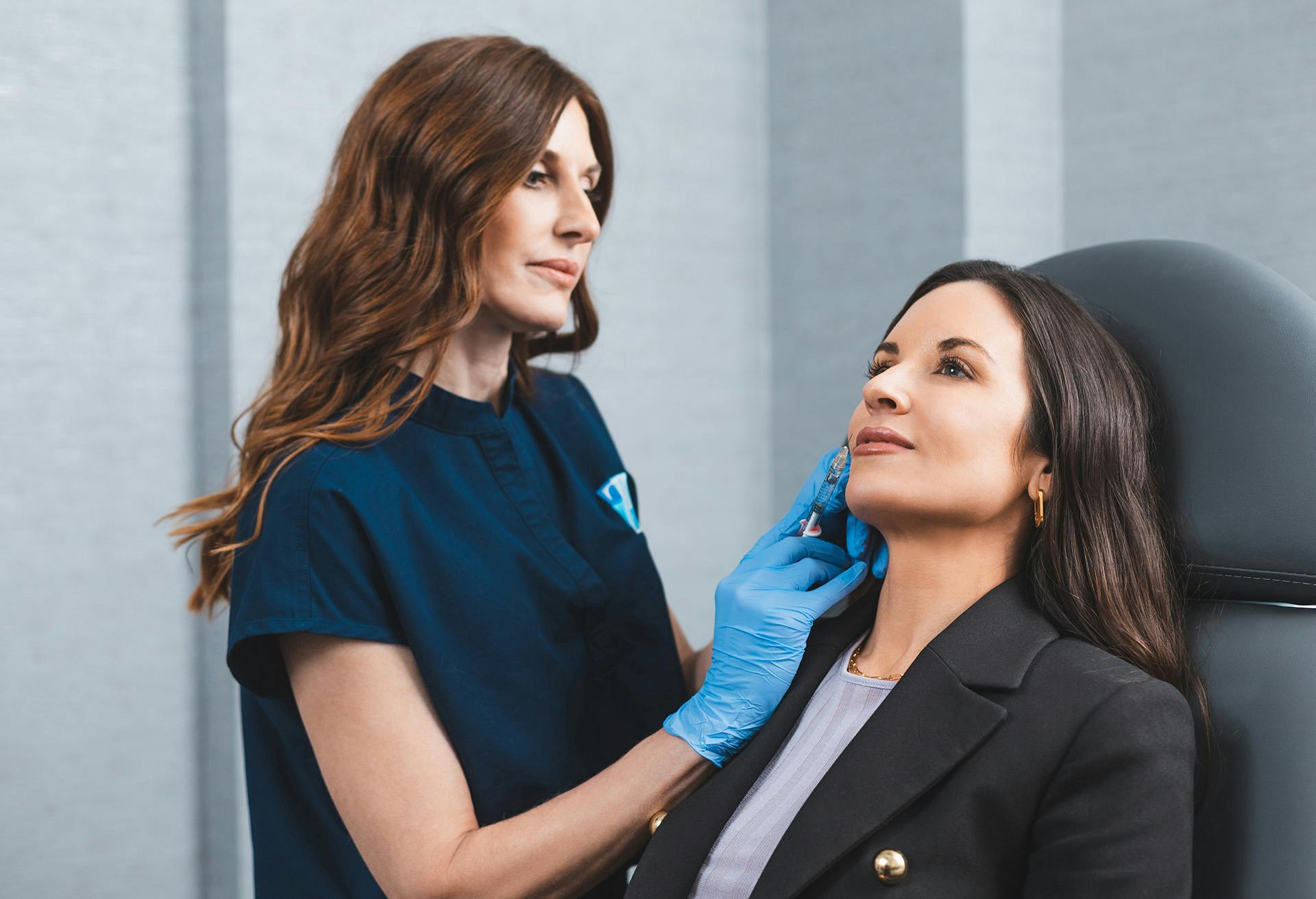 Tara Cypher injecting a woman with facial fillers