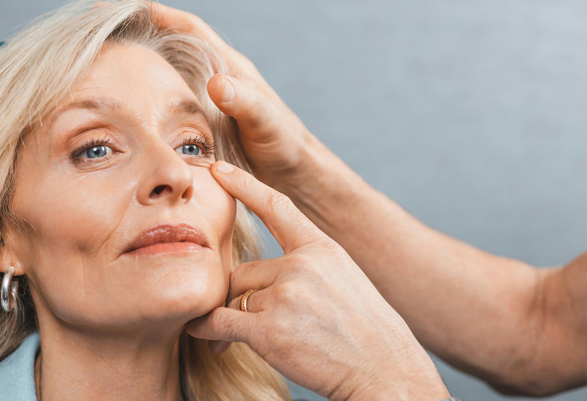 Woman with hands on her eyes getting her eyes looked at