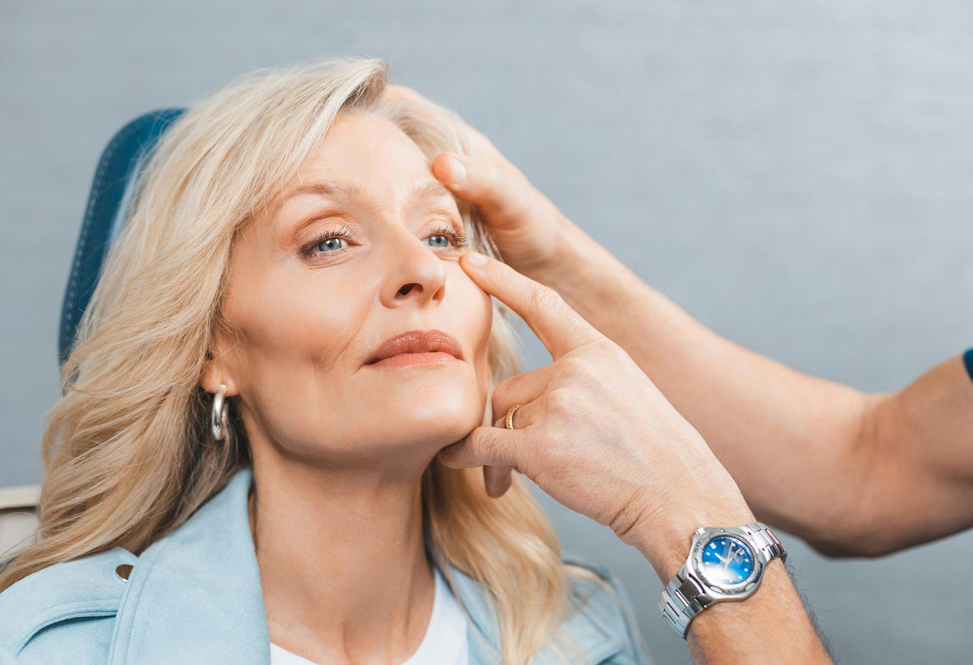Woman sitting in a chair with hands on her eyes