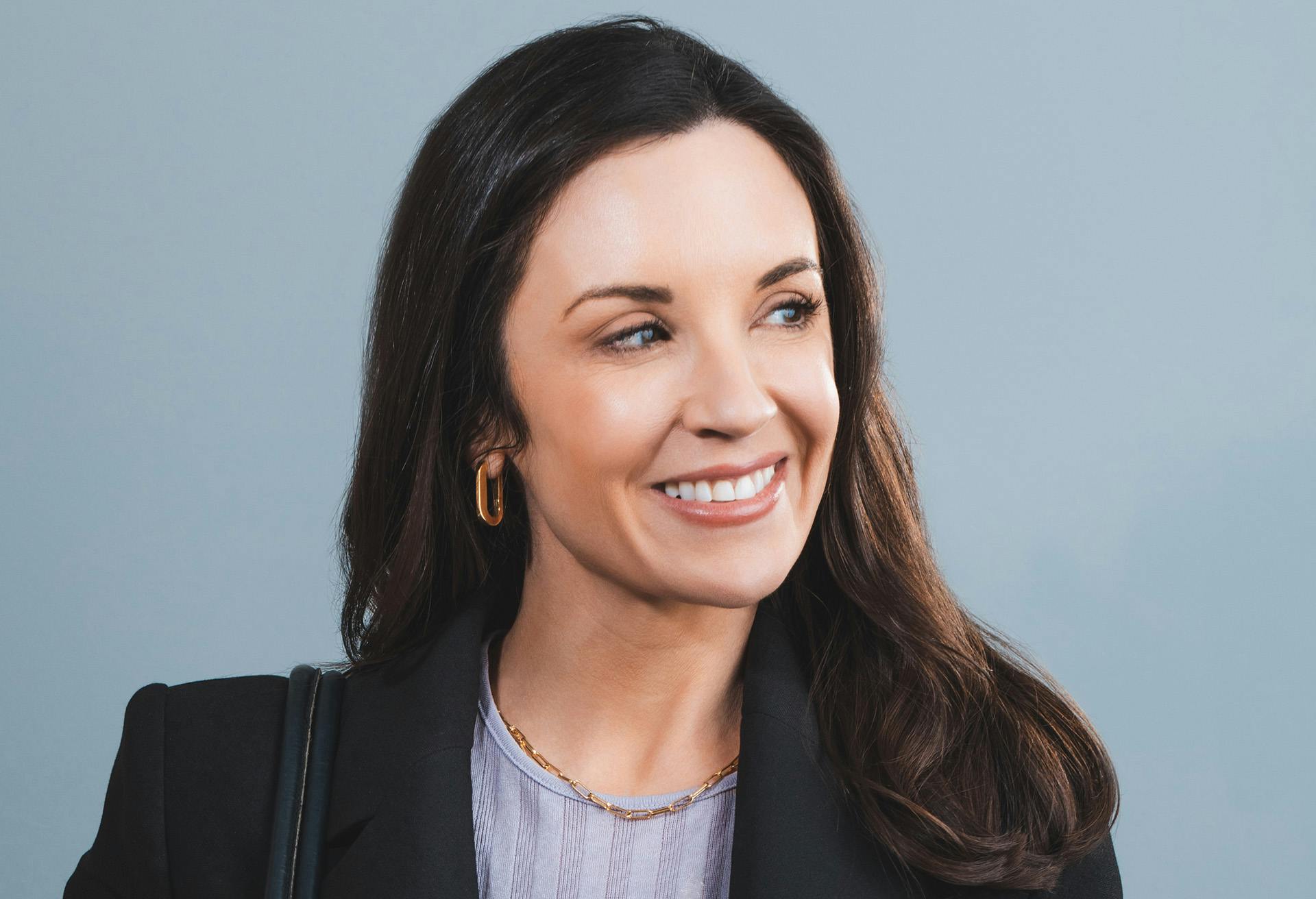 Woman in a black blazer looking to the side