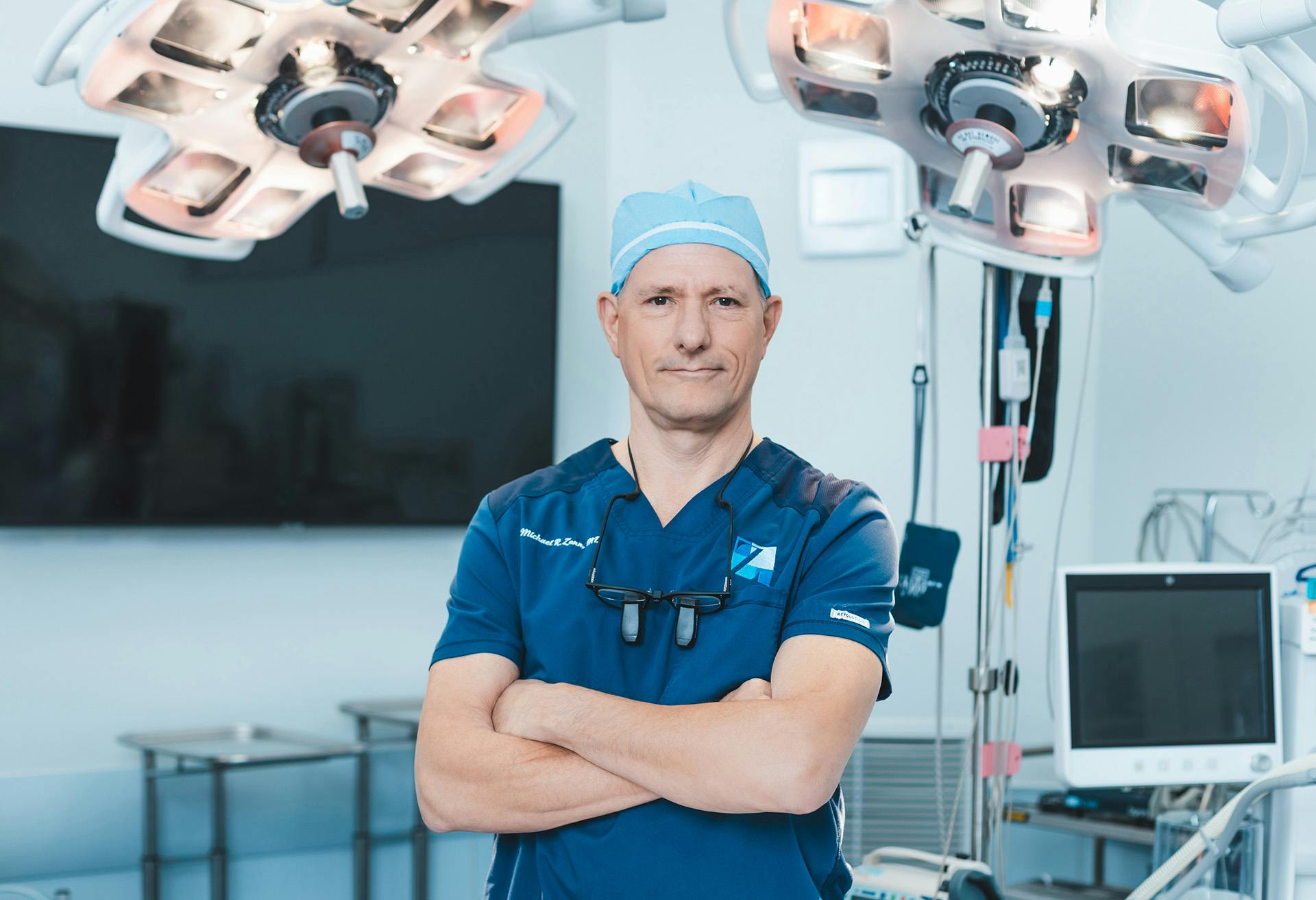 Dr. Zenn standing in an operating room with his arms crossed