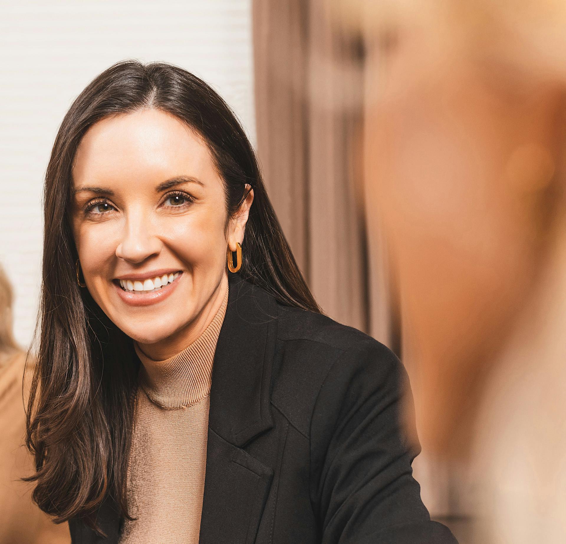 Woman in a black blazer smiling
