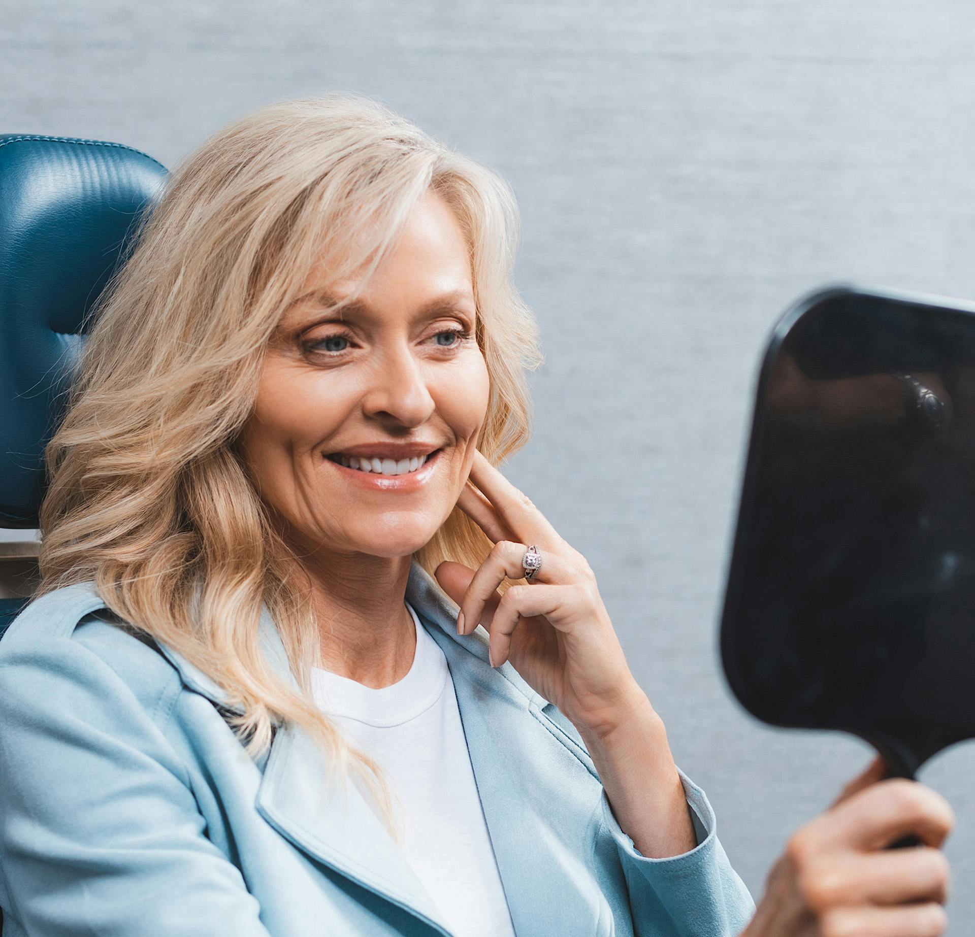 Woman smiling while looking into a mirror