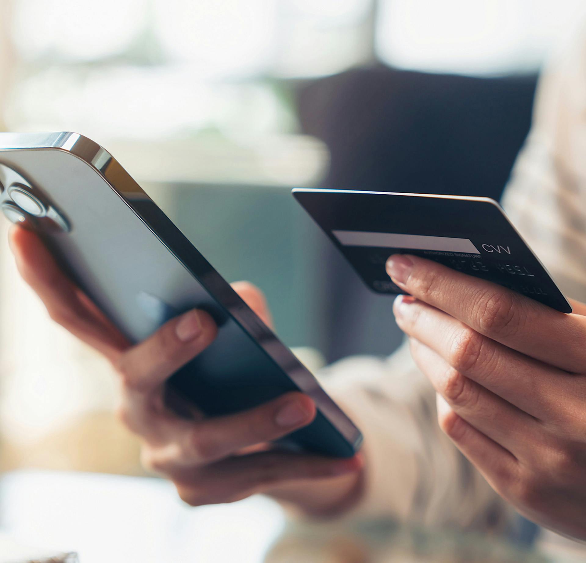 Woman holding her phone and credit card next to each other
