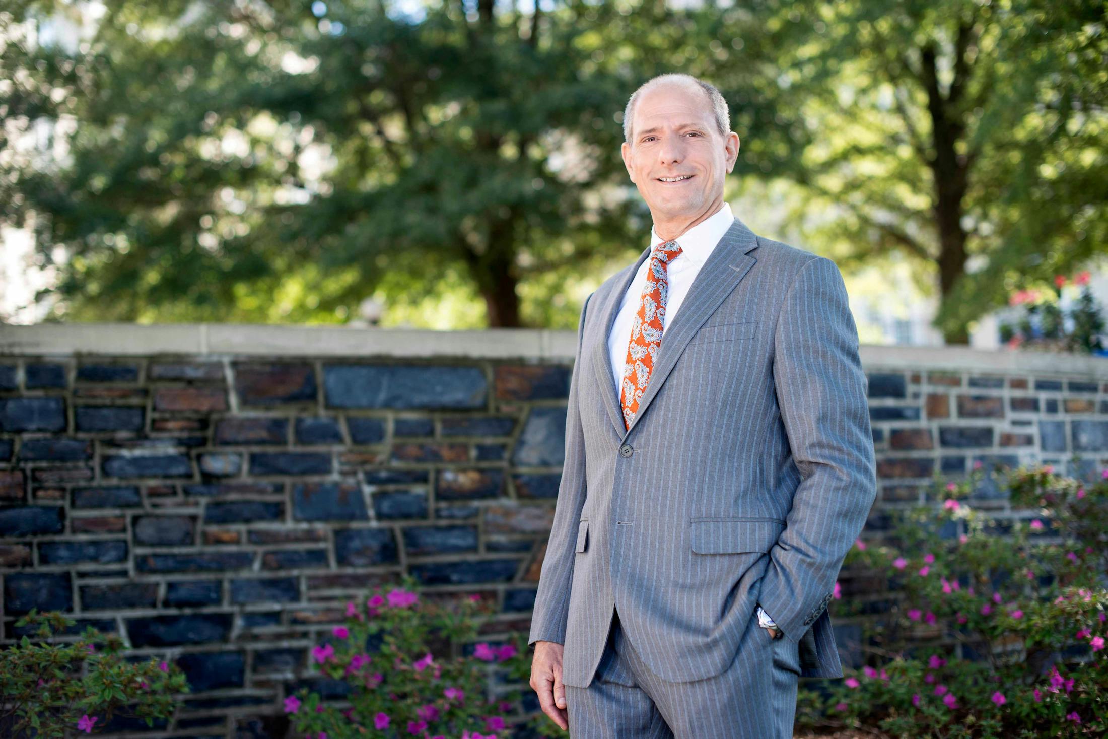 Dr. Zenn outside in front of a wall