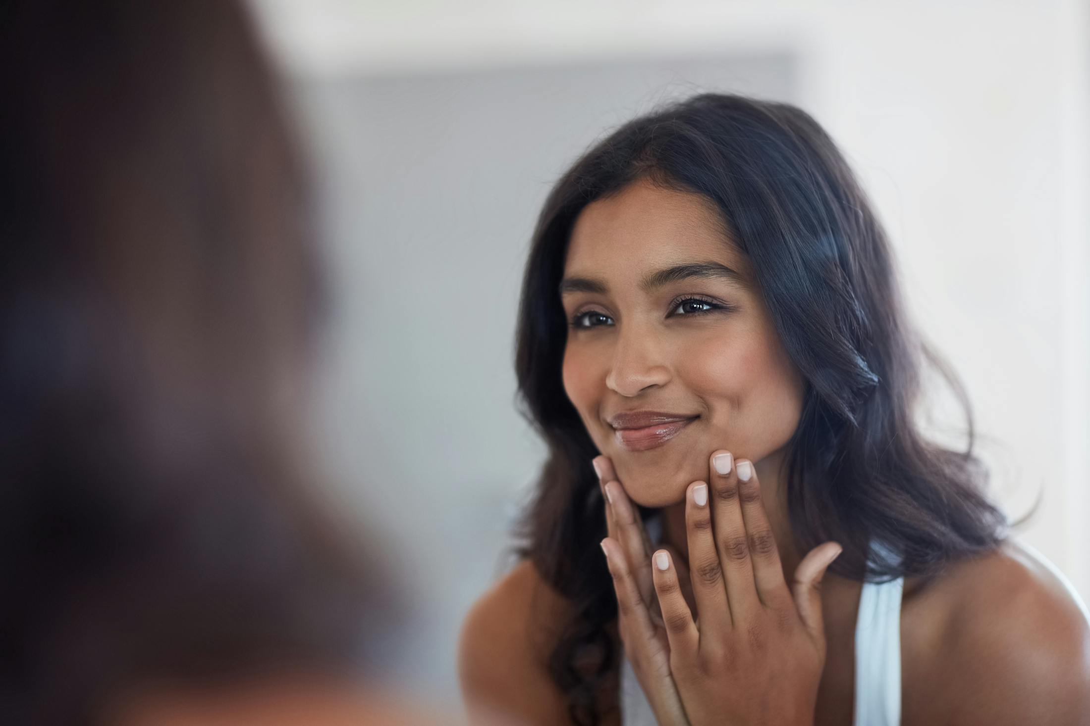 A girl looking at her face in the mirror