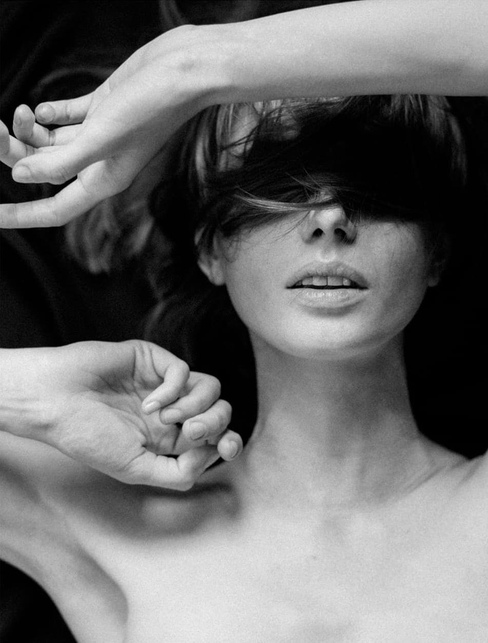 Woman with her bangs covering her eyes and her hands up near her face