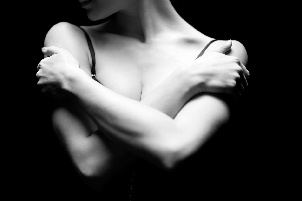 Woman crossing arms over her breasts