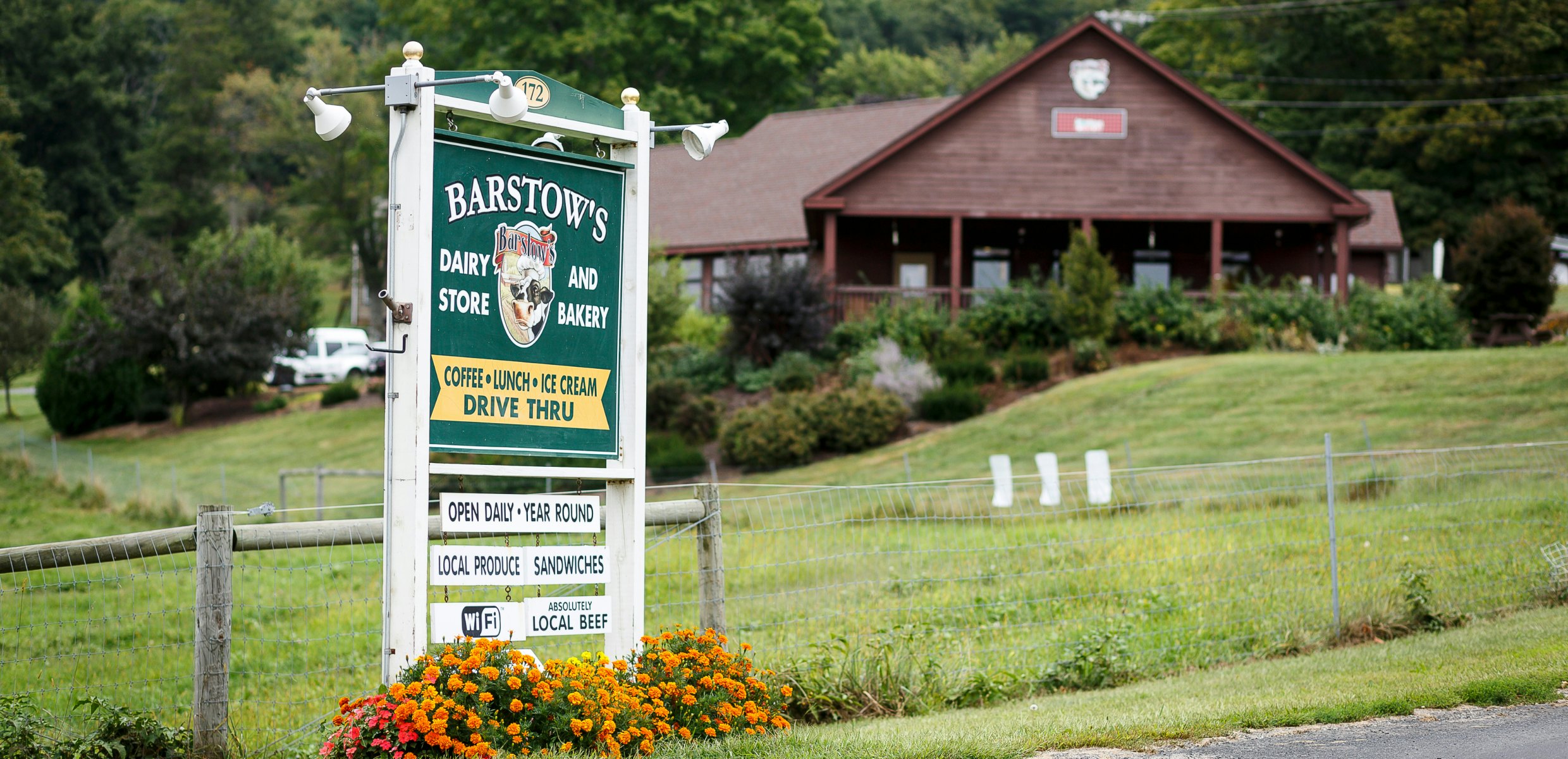 Sign for Barstow's Longview Farm, with building in the background