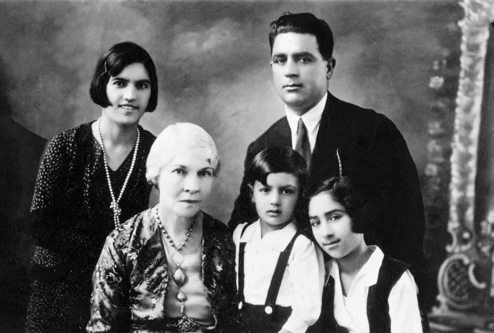 Hand of the Cause Keith Ransom-Kehler (seated at left) and the parents of Gloria Faizi, Rahmatu’llah Khan ‘Ala’i (standing at right) and Najmieh (standing at left), with Gloria (right) and her brother, Manuchihr