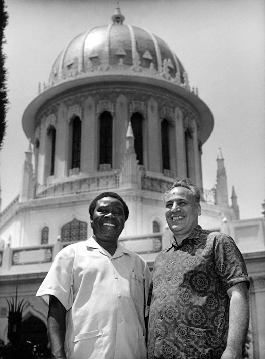 Hands of the Cause Enoch Olinga (left) and Rahmatu’lláh Muhájir (right) in front of the Shrine of the Báb, 1973
