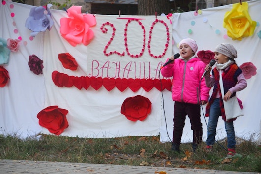 Two girls in Chișinău, Moldova, welcome their neighbors and friends to an outdoor celebration, where stories about Bahá’u’lláh were shared.