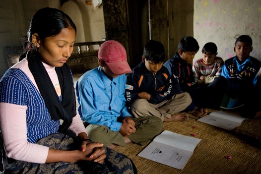 A group of youth pray before the beginning of their Baha'i junior youth study group in South Kanchanpur, Nepal
