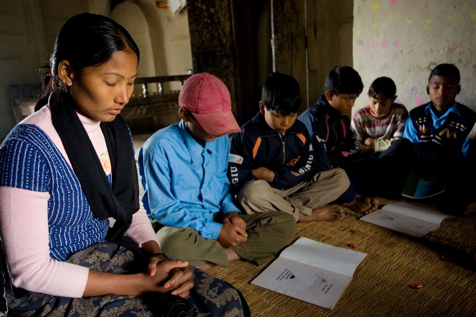 A group of youth pray before the beginning of their Baha'i junior youth study group in South Kanchanpur, Nepal