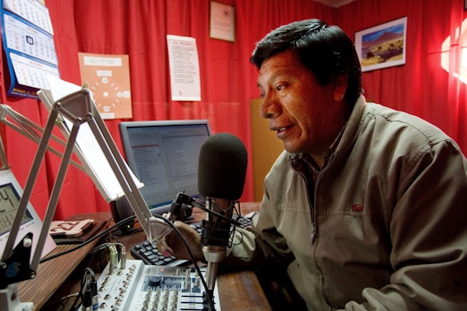 A radio announcer in the booth at Radio Baha'i in Caracollo, Bolivia