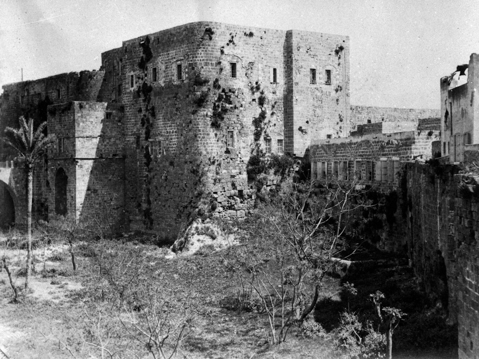 Prison of ‘Akká, where Bahá’u’lláh was incarcerated for a period of over two years -- the two windows farthest right on the second floor show the room that Bahá’u’lláh occupied in the prison, c. 1907