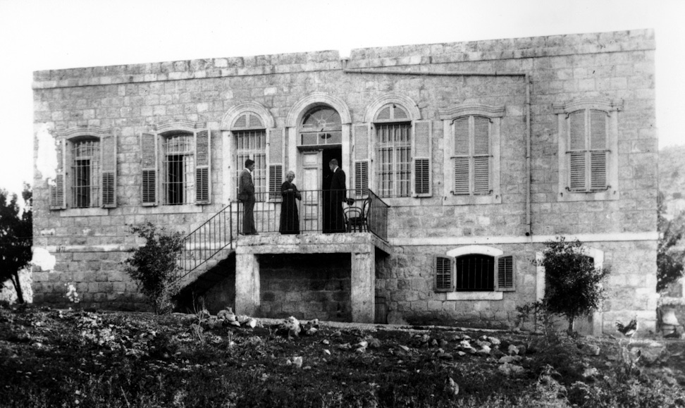 Three pilgrims on the steps of the Western Pilgrim House, c. 1925