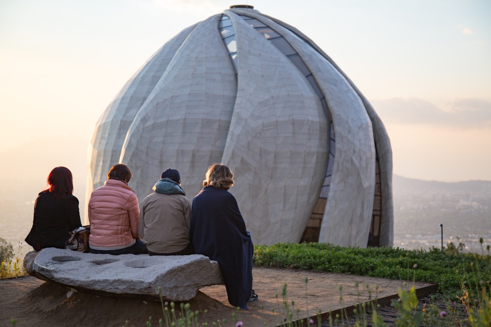 Visitors seated on a bench in the gardens of the Continental Bahá’í House of Worship of South America (Santiago, Chile)