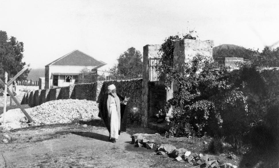 ‘Abdu’l-Bahá walking outside 7 Haparsim Street in Haifa, c. 1919