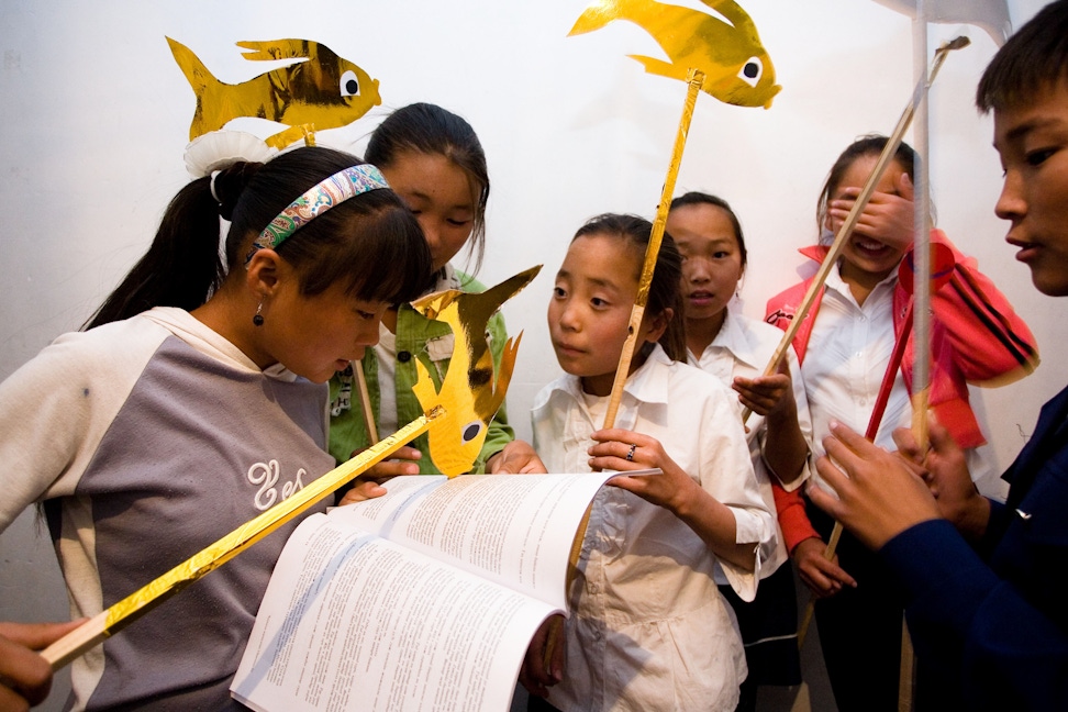 A group of children prepare a puppet show for a cluster reflection meeting at the Baha'i centre in Sainshand, Mongolia