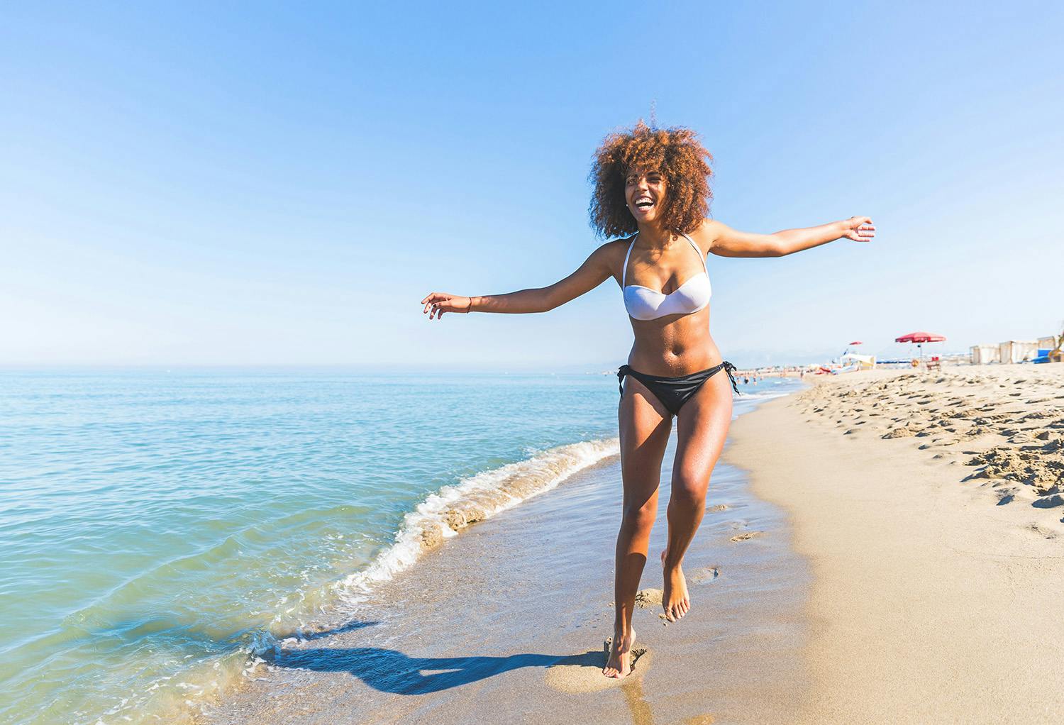 Woman in Bikini Running on the Beach
