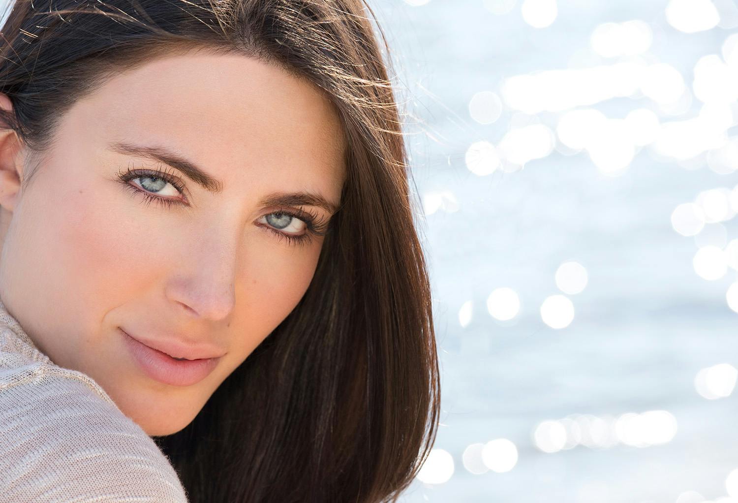 Woman with Dark Hair and Blue Eyes with the Ocean in the Background